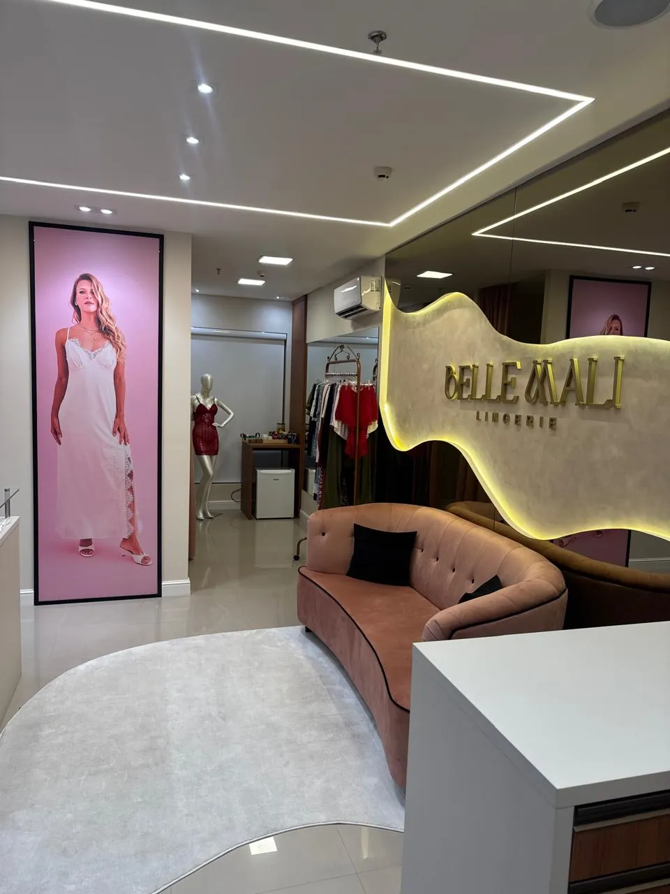Interior da loja Belle Mali com letreiro iluminado e lounge